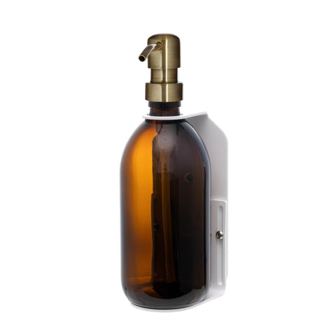 White wall mounted soap dispenser amber bottle and gold pump