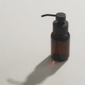 Kuishi Foaming dispenser sat on s shiny surface with colour reflecting 